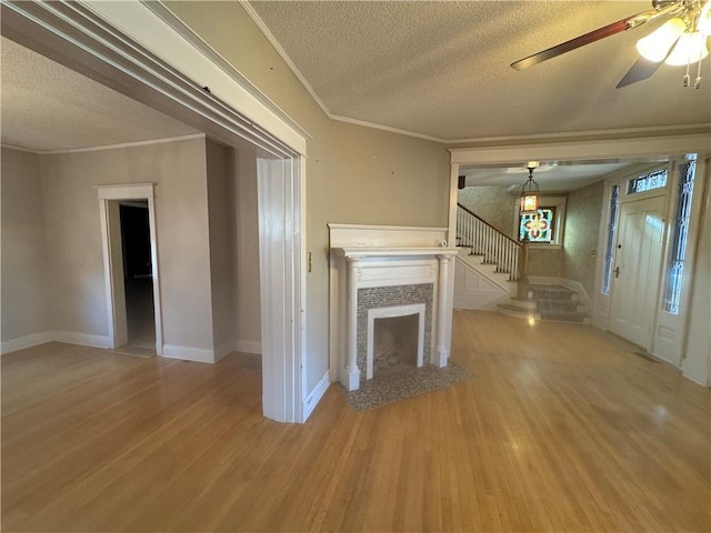 unfurnished living room featuring wood-type flooring, a textured ceiling, and crown molding