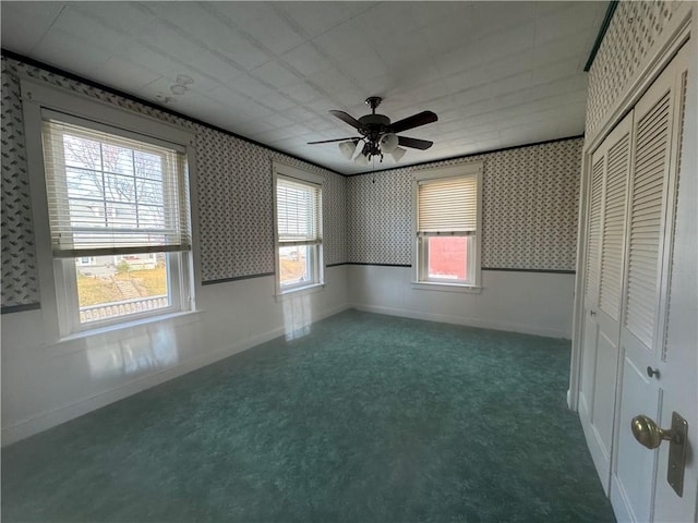 unfurnished bedroom with multiple windows, ceiling fan, and a closet