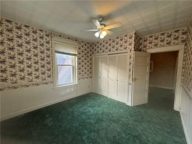 unfurnished bedroom with dark colored carpet, a closet, and ceiling fan