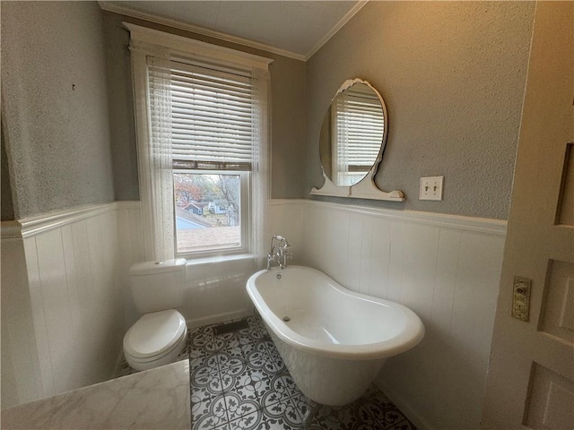 bathroom featuring a bathtub, tile patterned flooring, and ornamental molding