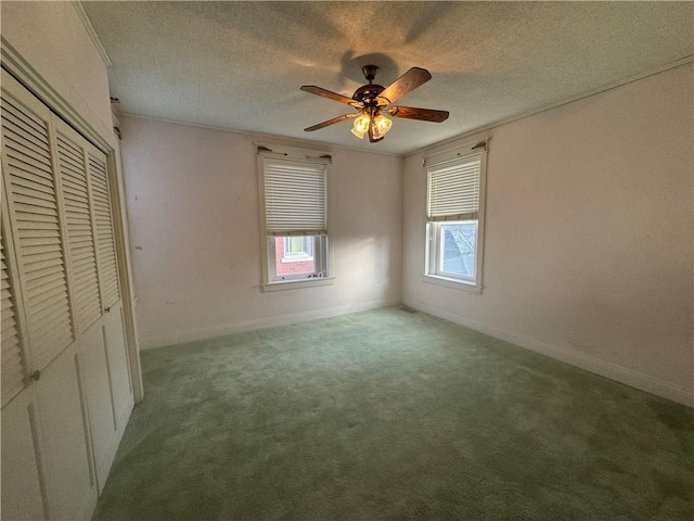 unfurnished bedroom featuring ceiling fan, a closet, light carpet, and a textured ceiling