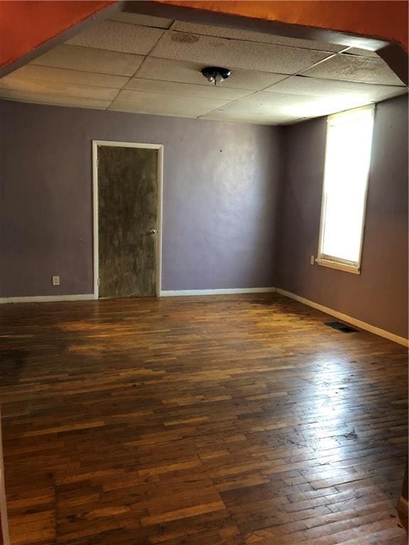 unfurnished room featuring a paneled ceiling and dark wood-type flooring