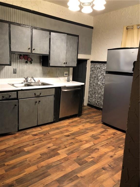 kitchen with dark wood-type flooring, stainless steel appliances, and sink