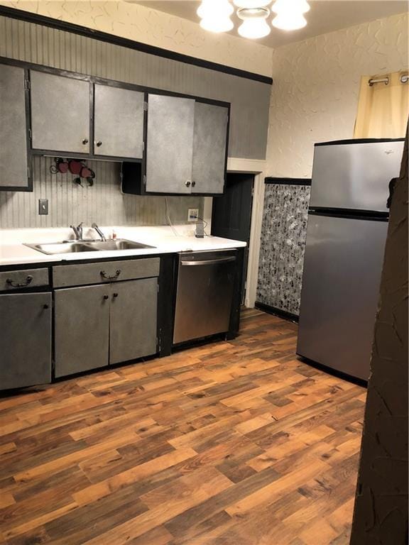 2720 Patee St, Saint Joseph, MO 64507 - kitchen with appliances with stainless steel finishes, a sink, wood finished floors, light countertops, and a textured wall