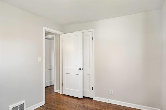 unfurnished bedroom with dark hardwood / wood-style flooring