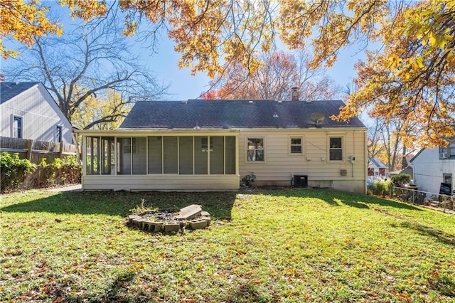 back of property featuring a sunroom and a lawn