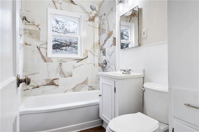 full bathroom with tiled shower / bath combo, vanity, tile walls, and toilet