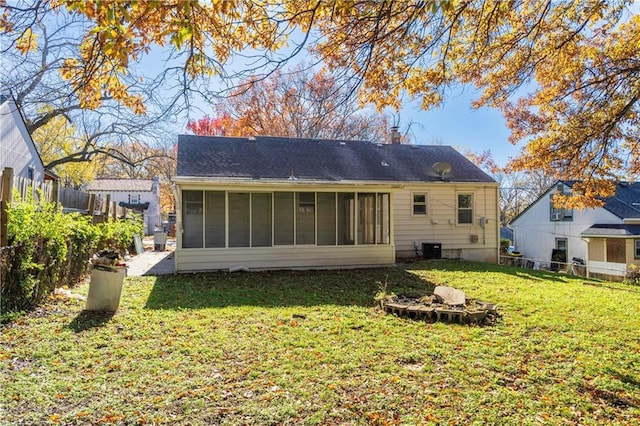 rear view of property featuring a sunroom, a yard, and central air condition unit