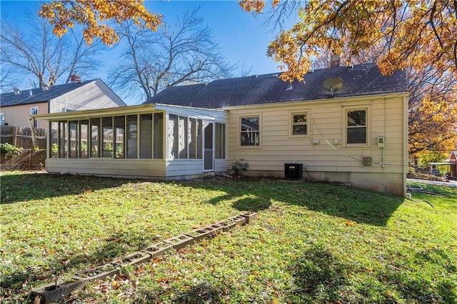 rear view of property with a sunroom and a yard