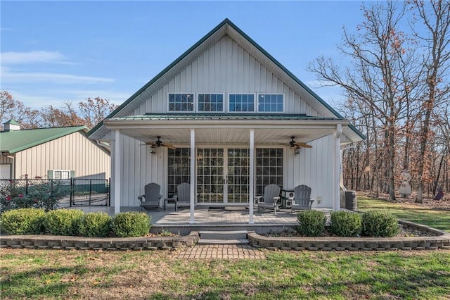 back of property with a lawn, ceiling fan, and central AC unit