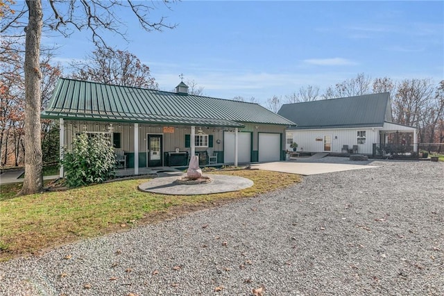 back of house with covered porch and a garage