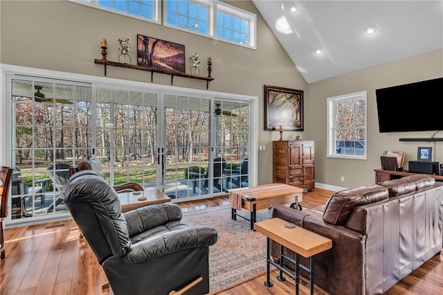 living room featuring hardwood / wood-style flooring, high vaulted ceiling, plenty of natural light, and ceiling fan