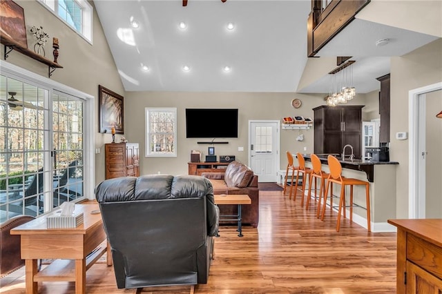 living room with light hardwood / wood-style flooring and high vaulted ceiling