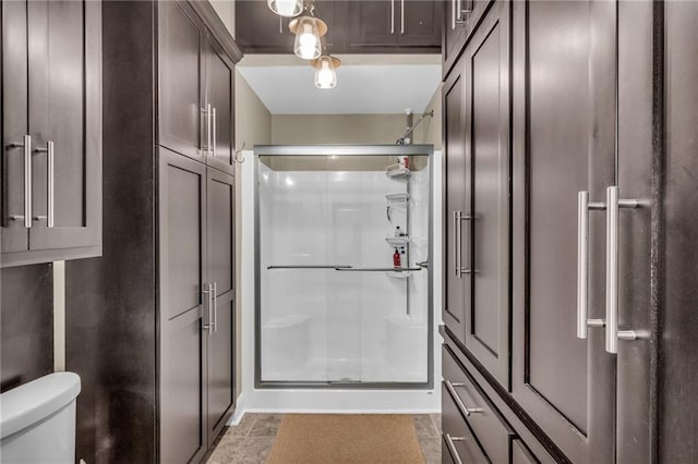 bathroom with tile patterned floors, toilet, and walk in shower