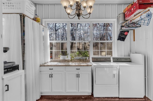 laundry room featuring washer and dryer, cabinets, a chandelier, and wood walls