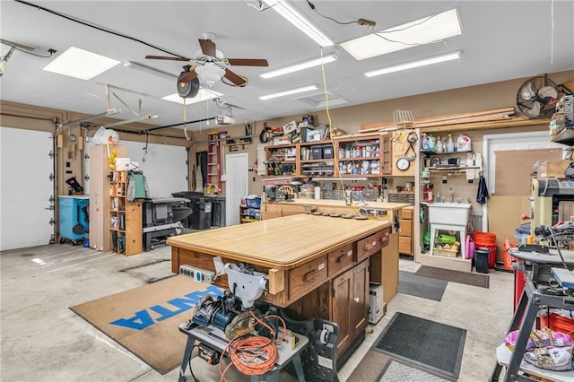 garage with a workshop area, ceiling fan, and a garage door opener