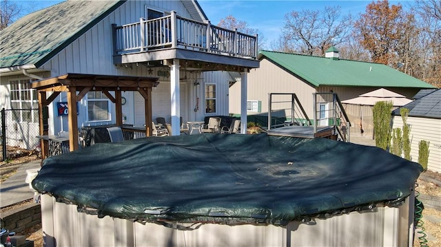 back of property featuring a balcony and a covered pool