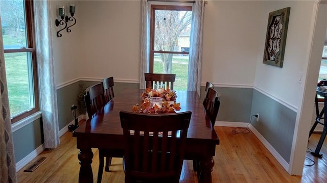 dining room with light hardwood / wood-style floors and a healthy amount of sunlight