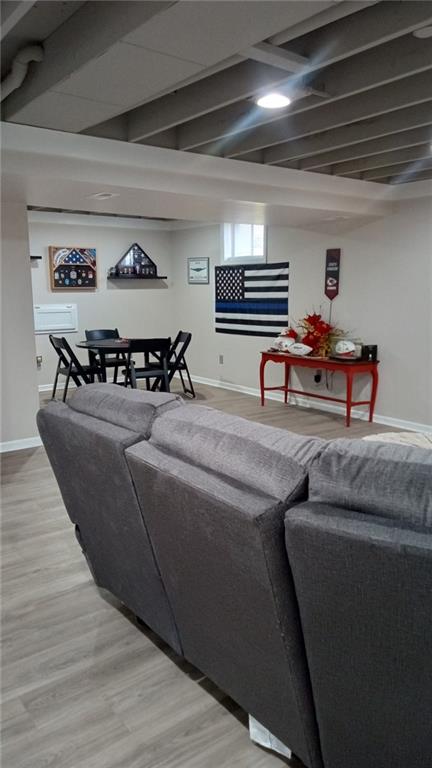 living room featuring beamed ceiling and wood-type flooring