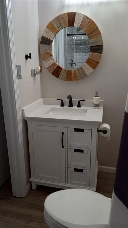 bathroom featuring wood-type flooring, vanity, and toilet