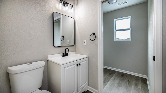 bathroom with hardwood / wood-style flooring, vanity, and toilet