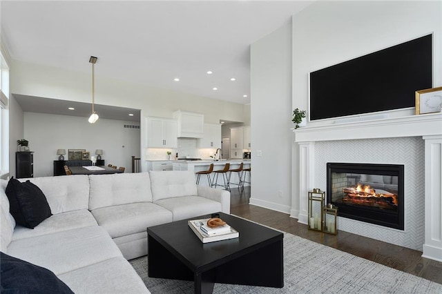 living room featuring dark hardwood / wood-style flooring and a tiled fireplace