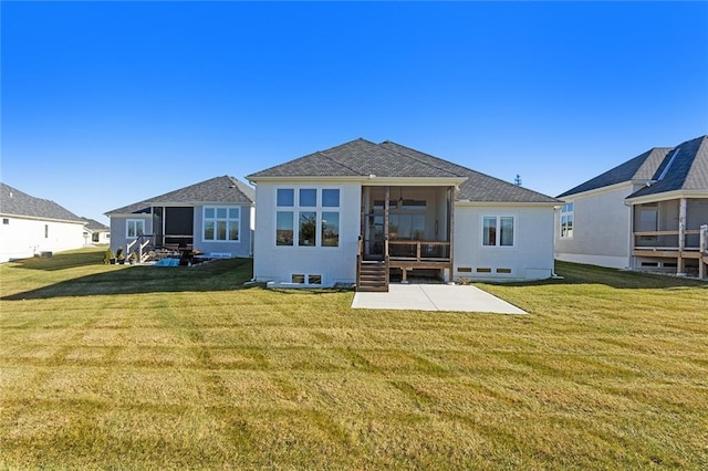 rear view of property with a yard, a patio area, and a sunroom