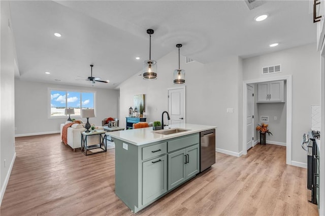 kitchen featuring pendant lighting, sink, stainless steel appliances, a center island with sink, and light hardwood / wood-style flooring