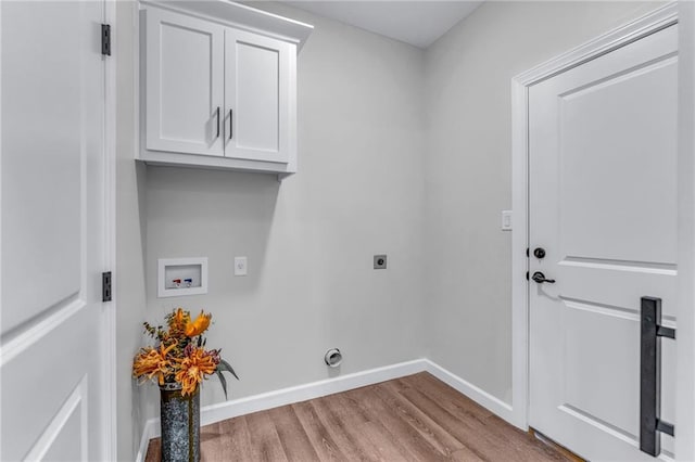 washroom with cabinets, electric dryer hookup, hookup for a washing machine, and light wood-type flooring