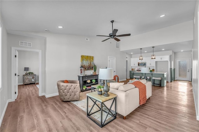 living room with ceiling fan and light wood-type flooring