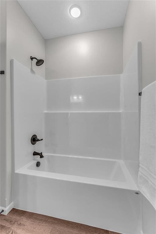 bathroom with hardwood / wood-style flooring and shower / bathtub combination