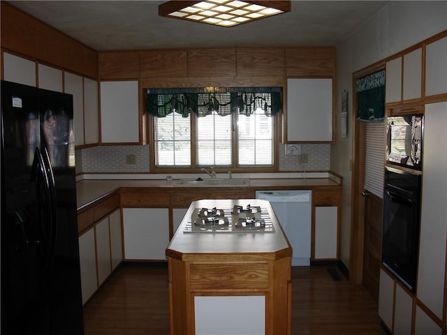 kitchen featuring white cabinets, dark hardwood / wood-style floors, a kitchen island, and black appliances