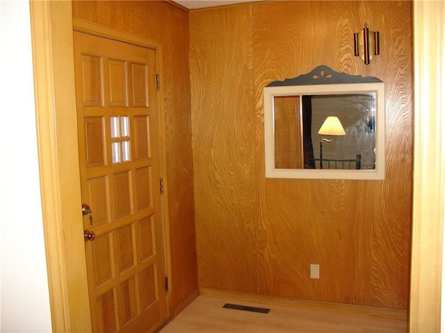 entrance foyer with wood-type flooring and wooden walls