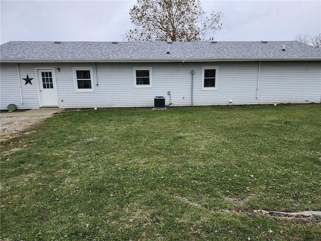 rear view of property featuring a yard and central AC unit