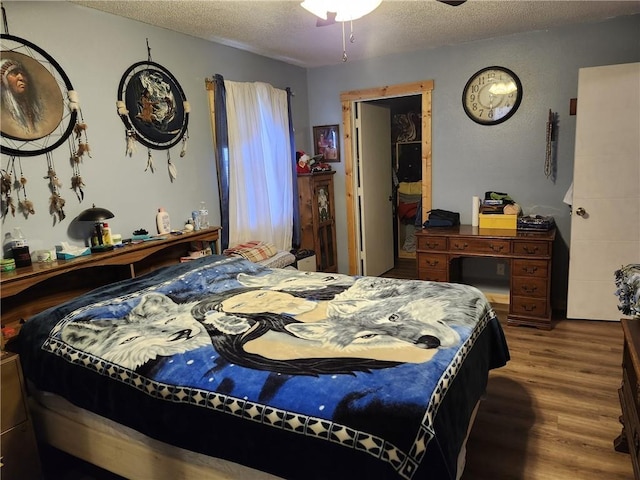 bedroom with dark hardwood / wood-style floors and a textured ceiling