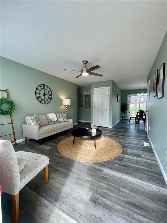 living room with dark hardwood / wood-style floors and ceiling fan