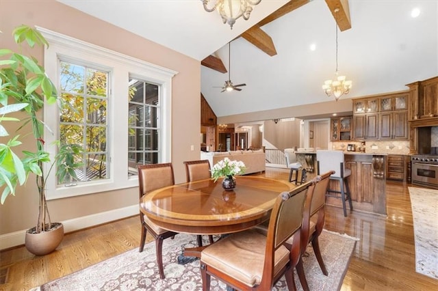 dining room with beam ceiling, high vaulted ceiling, light hardwood / wood-style floors, and ceiling fan with notable chandelier