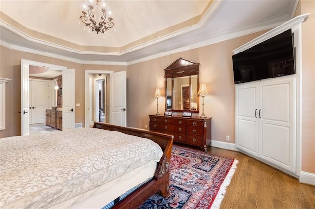 bedroom featuring a raised ceiling, light hardwood / wood-style flooring, and ornamental molding