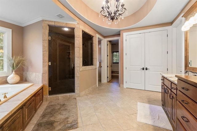 bathroom featuring a tray ceiling, vanity, plus walk in shower, and an inviting chandelier