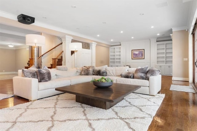 living room featuring dark hardwood / wood-style floors, built in features, and crown molding