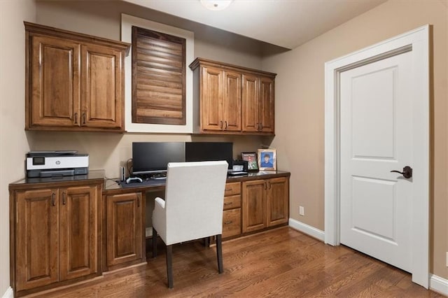 office area with built in desk and dark wood-type flooring