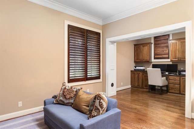 home office with ornamental molding, built in desk, and wood-type flooring