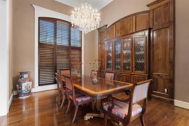 dining area featuring dark hardwood / wood-style flooring and an inviting chandelier