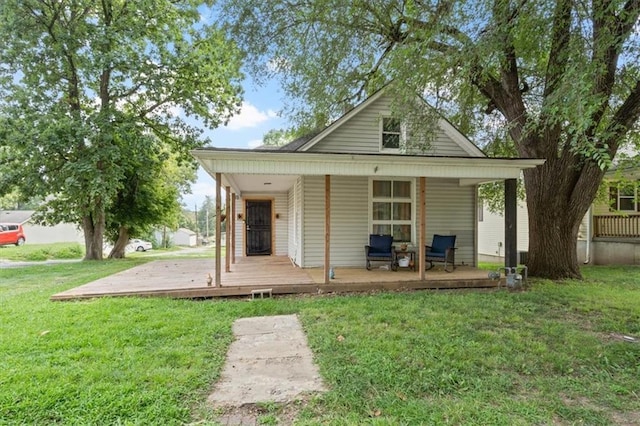 back of property with covered porch and a lawn