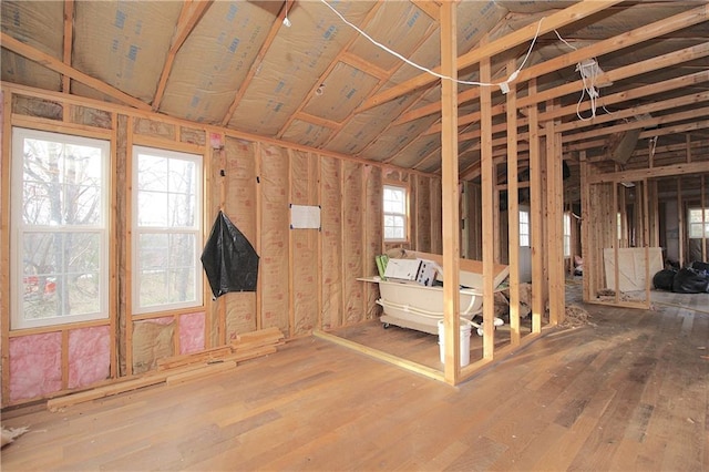 miscellaneous room with vaulted ceiling and hardwood / wood-style flooring