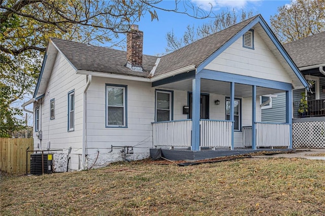 view of front of property with central AC, a front lawn, and covered porch