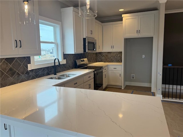 kitchen with stainless steel appliances, tasteful backsplash, white cabinets, a sink, and light stone countertops