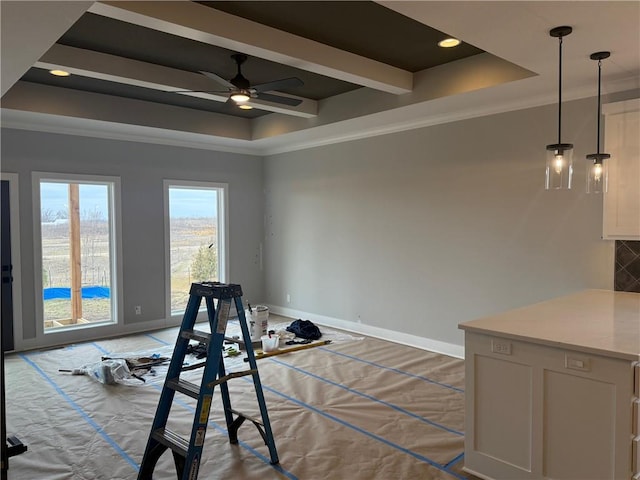 exercise area with crown molding, a tray ceiling, a ceiling fan, and baseboards