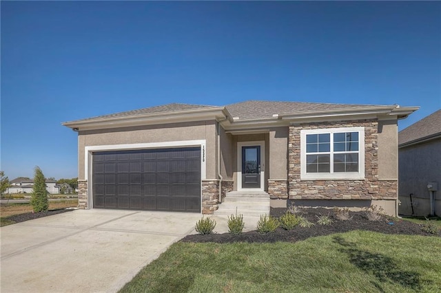 prairie-style house featuring stone siding, an attached garage, driveway, and stucco siding