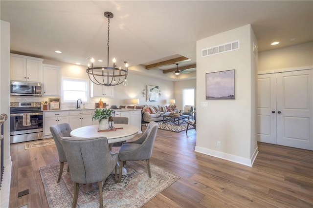 dining area featuring dark wood-type flooring, beam ceiling, visible vents, and baseboards